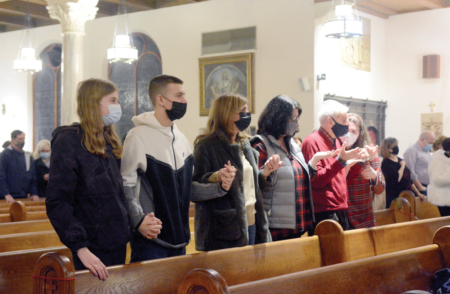 The faithful pray in the pews.