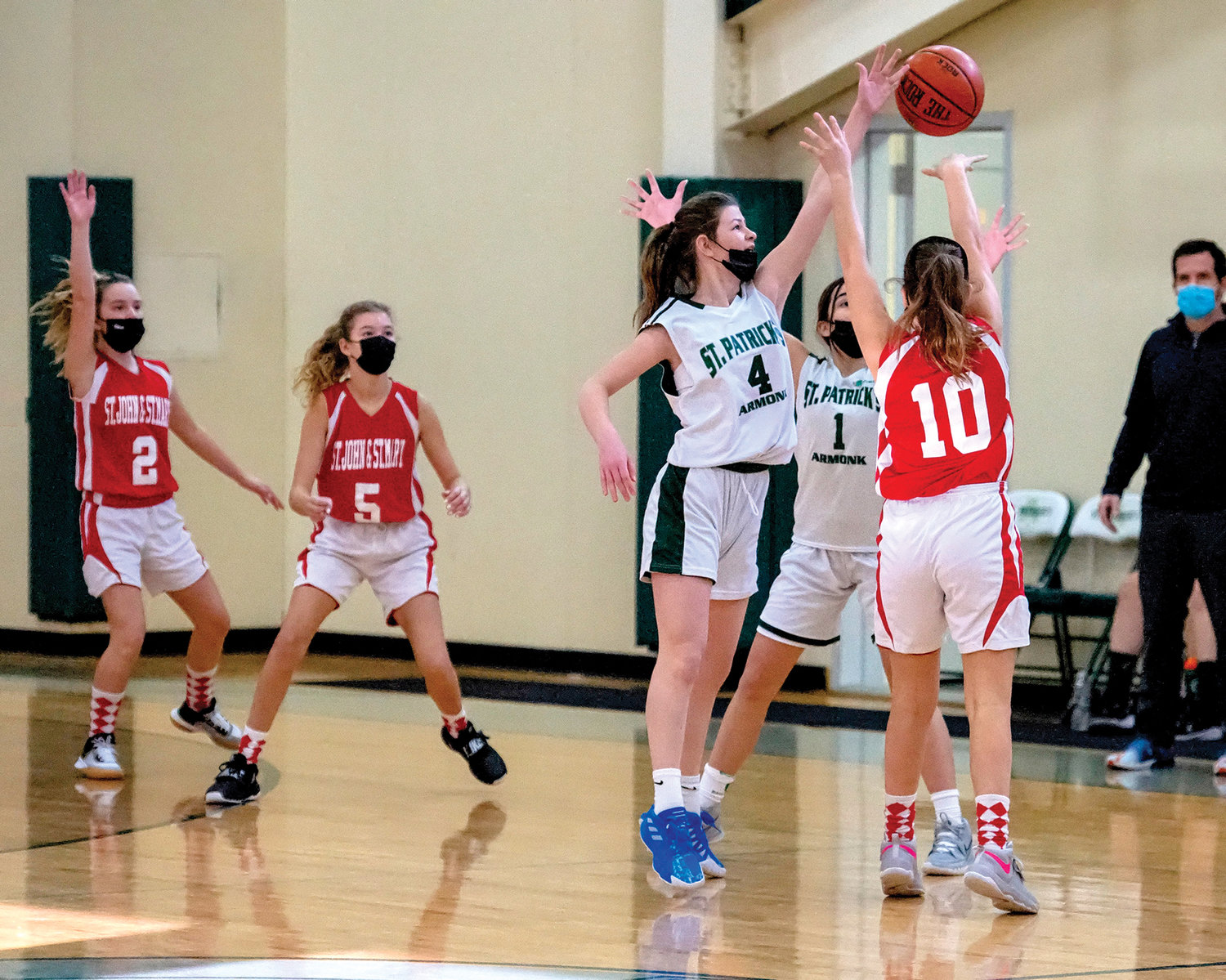 Avery Fitzgerald of St. John and St. Mary in Chappaqua looks to make a pass through St. Patrick defenders Lucy Brescio, left, and Brielle Delgrosso during a CYO eighth-grade girls basketball game at St. Patrick’s in Armonk Feb. 5. St. Patrick’s won, 28-26.