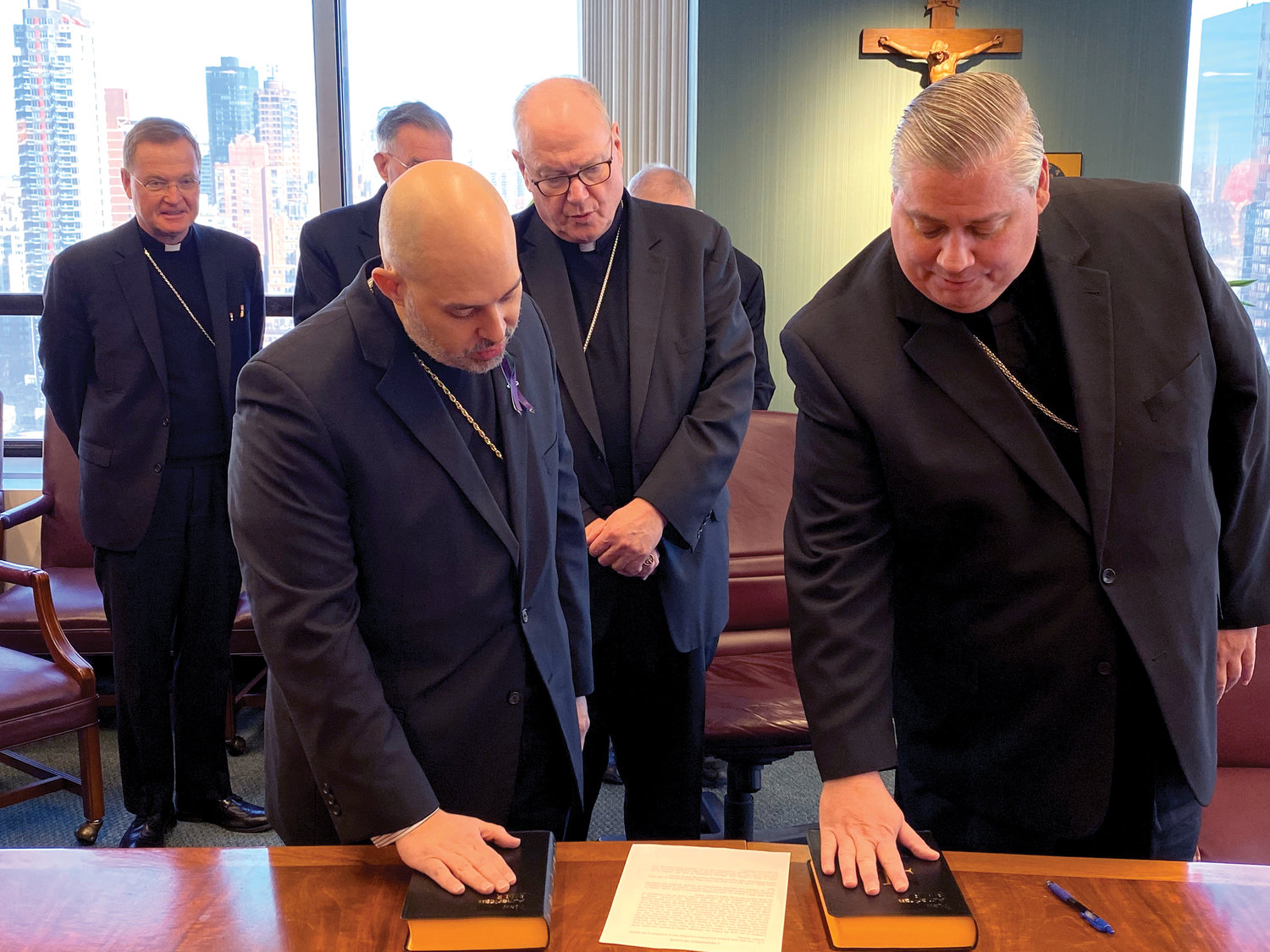 Bishop-elect Joseph Espaillat and Bishop-elect John Bonnici make their oath of fidelity and profession of faith witnessed by Cardinal Dolan Feb. 15 in the New York Catholic Center in Manhattan. The cardinal will ordain them as bishops March 1 in St. Patrick’s Cathedral.
