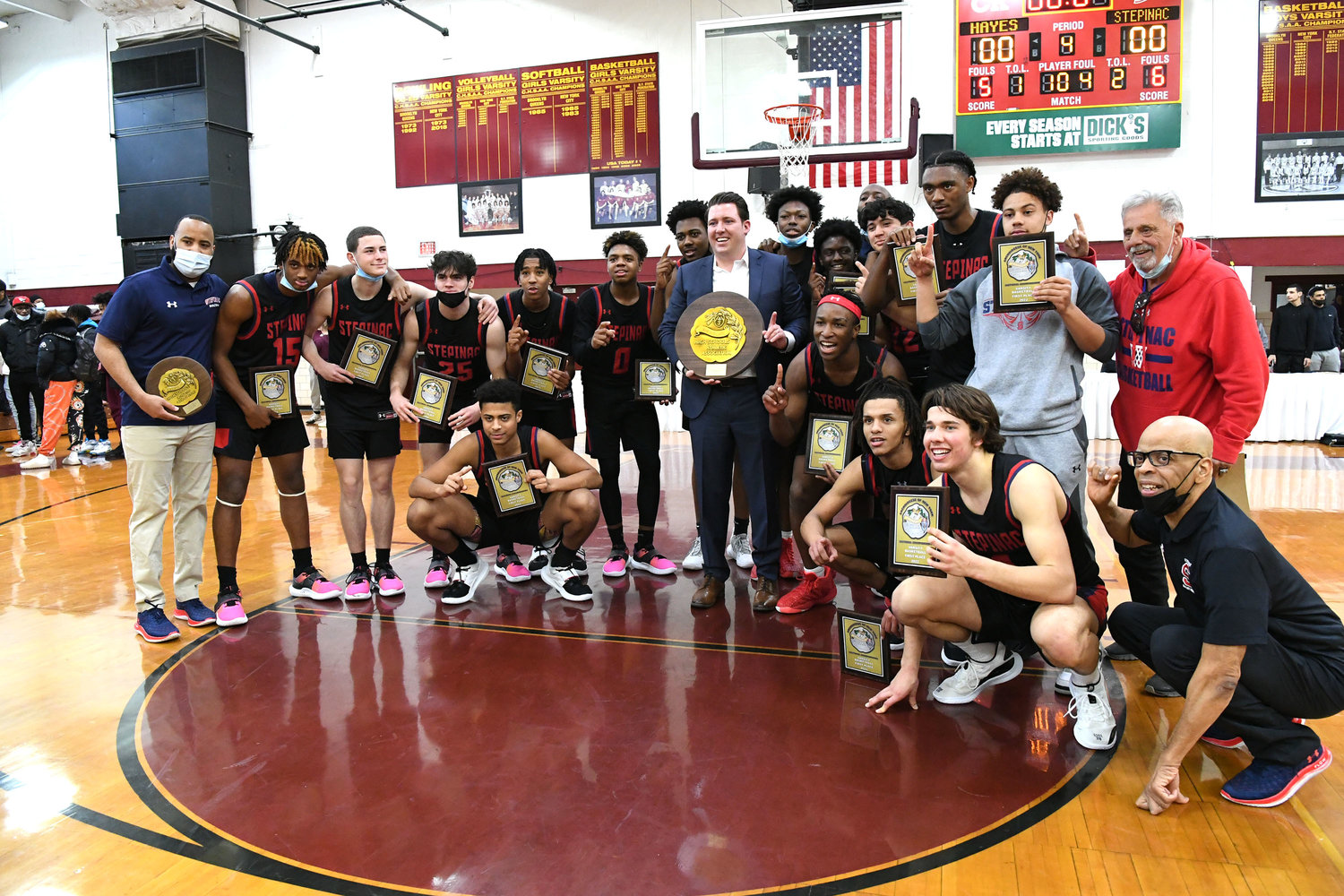 Archbishop Stepinac High School boys’ basketball players and coaches hold their championship plaques following a 51-40 victory over Cardinal Hayes in the Archdiocesan championship game.