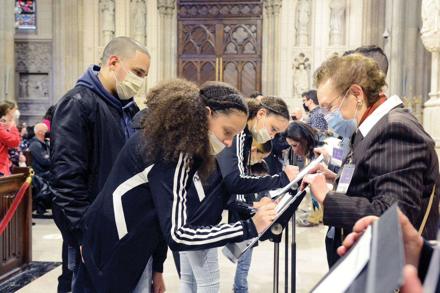 FAITHFUL STEP—Catechumens sign the Book of the Elect during the March 6 Rite of Election at St. Patrick’s Cathedral. They are preparing to enter the Catholic Church in their parishes at the Easter Vigil, April 16, when they will receive the sacraments of initiation. Full coverage on Page 3.