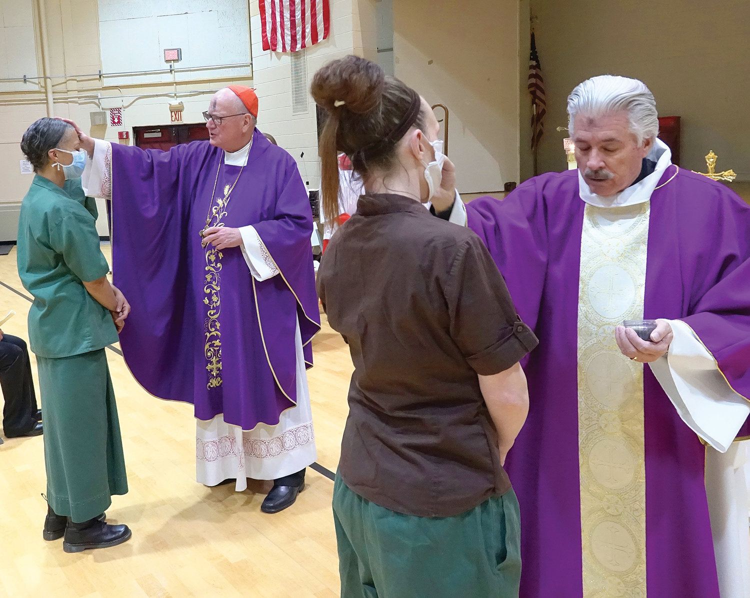 Cardinal Dolan and Deacon Clifford Calanni, the prison chaplain, distribute ashes.