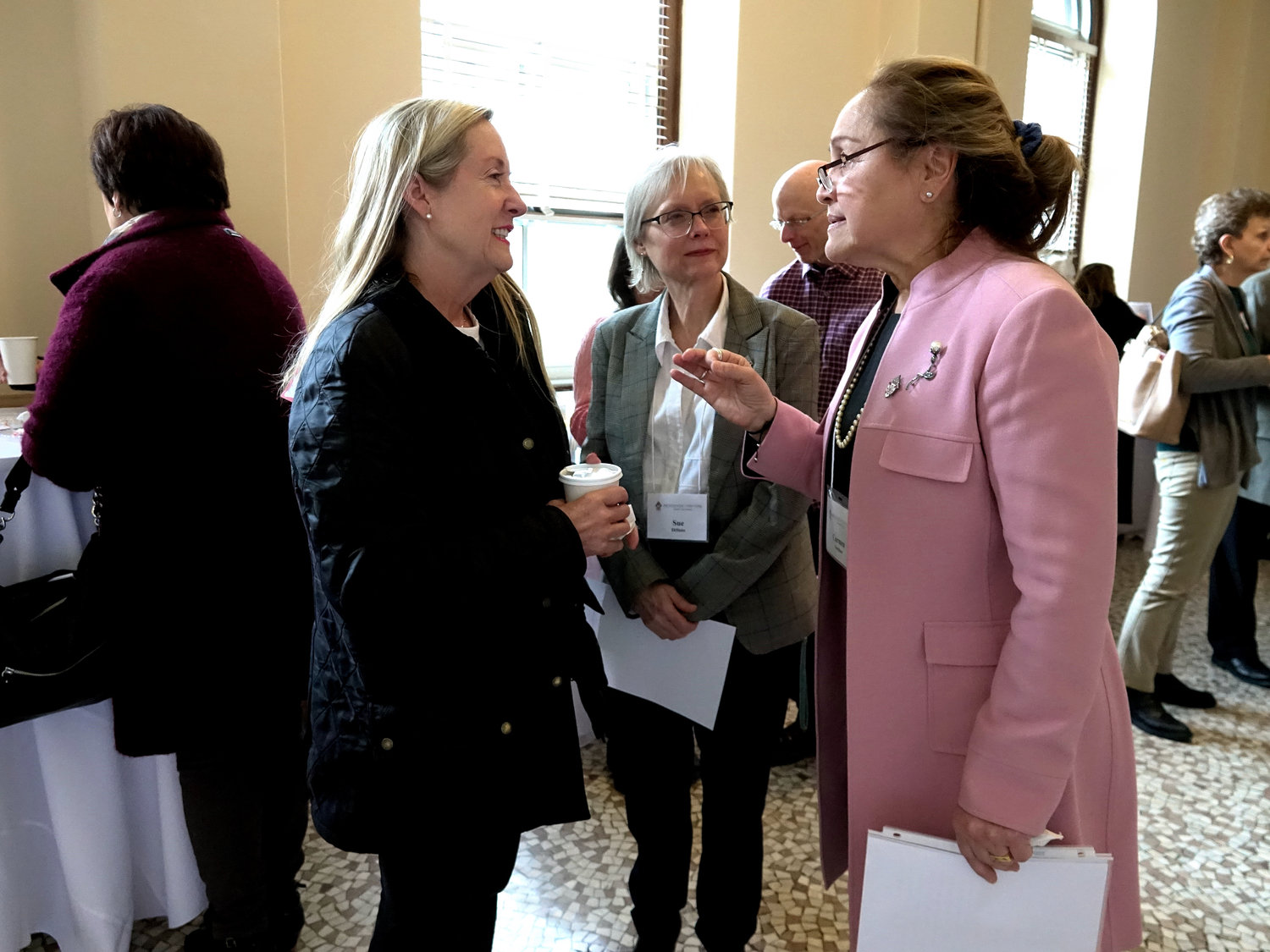Attendee Marypat Hughes, left, converses with representatives from the Family Life Office, Sue DiSisto and Carmen Noschese, far right.