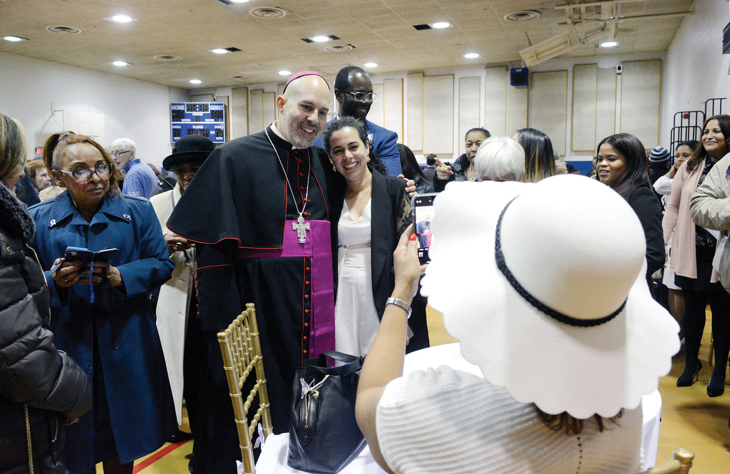 Auxiliary Bishop Joseph Espaillat enthusiastically poses for photos at a reception at Cathedral High School in the New York Catholic Center in Manhattan March 1.