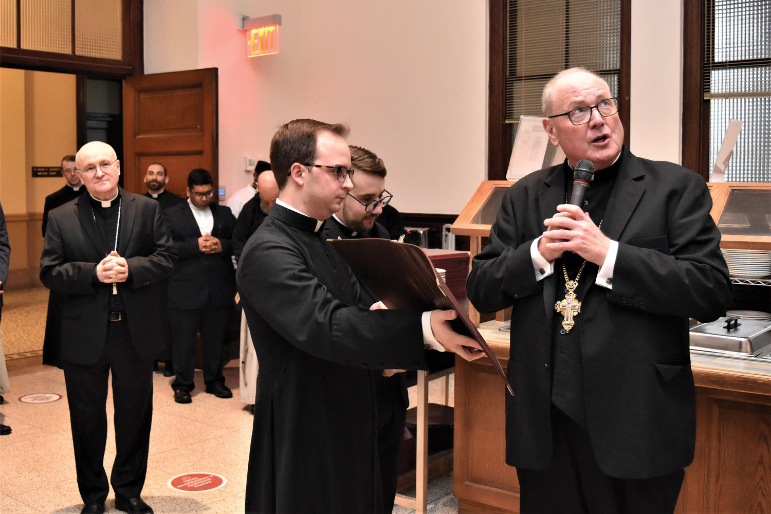 Cardinal Dolan delivers a final blessing at a reception for the closing of the 125th anniversary year. The seminarian holding the prayer book is Andrew LeFleur of the Diocese of Bridgeport, Conn., and to the left is Brooklyn Auxiliary Bishop James Massa, seminary rector.