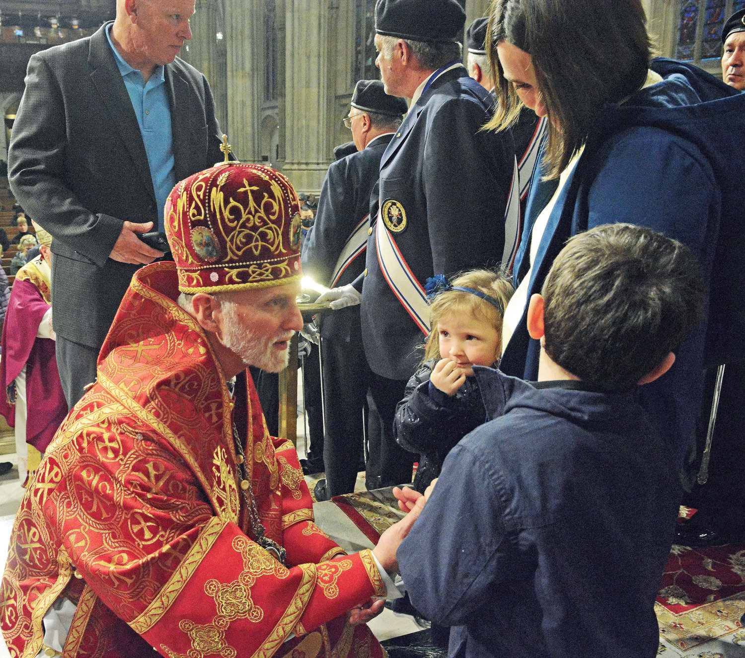 Archbishop Borys Gudziak of the Ukrainian Catholic Archeparchy of Philadelphia greets young Elizabeth and Eugene Rodomon along with their mother, Katarina, who escaped the war in Ukraine three weeks ago and are being assisted by a parish in Belle Harbor, Queens. They were at St. Patrick’s Cathedral April 3 for a Mass Cardinal Dolan offered for the world’s persecuted Christians.