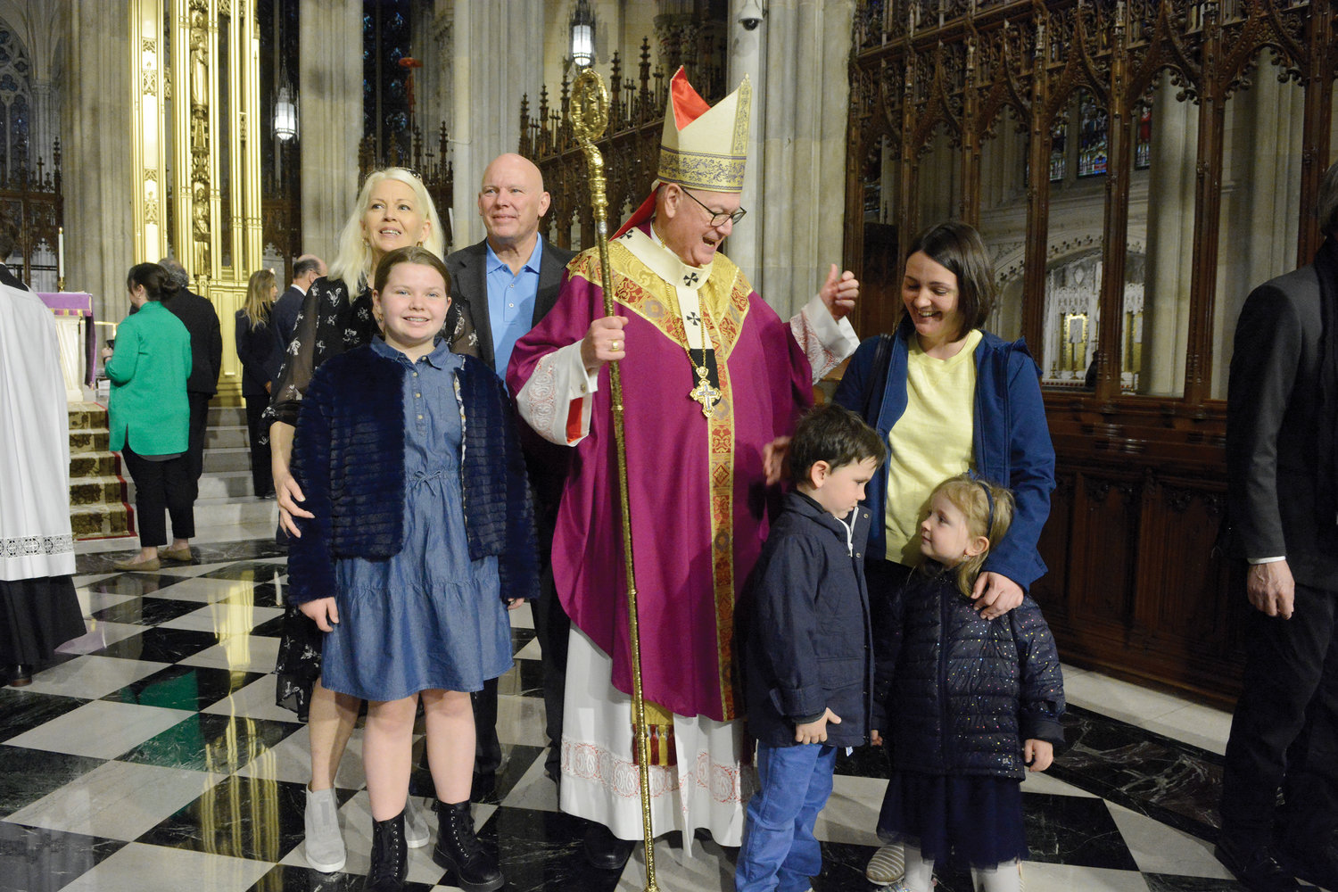 The cardinal greets a family from the Yavorif, Ukraine, which recently came to Belle Harbor, Queens, where they are being assisted by St. Francis de Sales parish. At right are Katarina Rodomon and her young children, Eugene and Elizabeth. At left are Monica and Patrick Keane and their daughter, Olivia, parishioners of St. Francis de Sales.