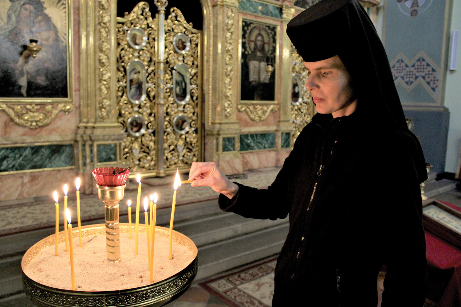 SANCTUARY—Sister Evphrosynia Senyk, a member of the Ukrainian Catholic Church’s St. Joseph Sisters, lights a candle in the sanctuary of the Ukrainian Catholic parish of the Exaltation of the Holy Cross, formerly the Church of St. Norbert, in Krakow, Poland. The church has become a haven for Ukrainians fleeing the Russian war in Ukraine.
