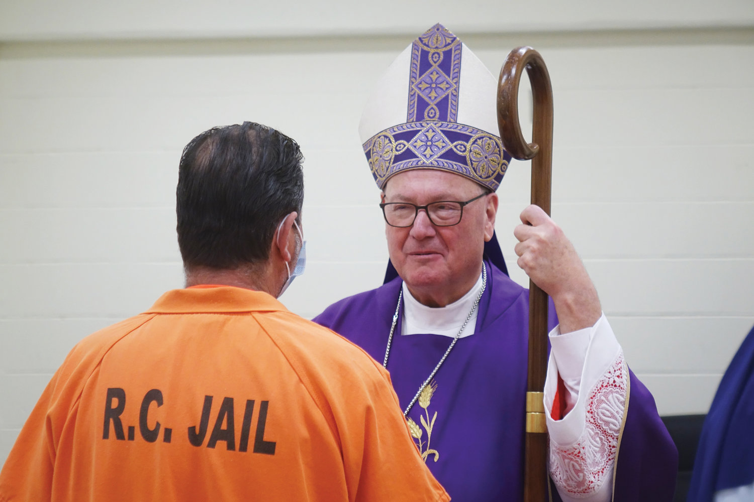 Cardinal Dolan speaks with an inmate.