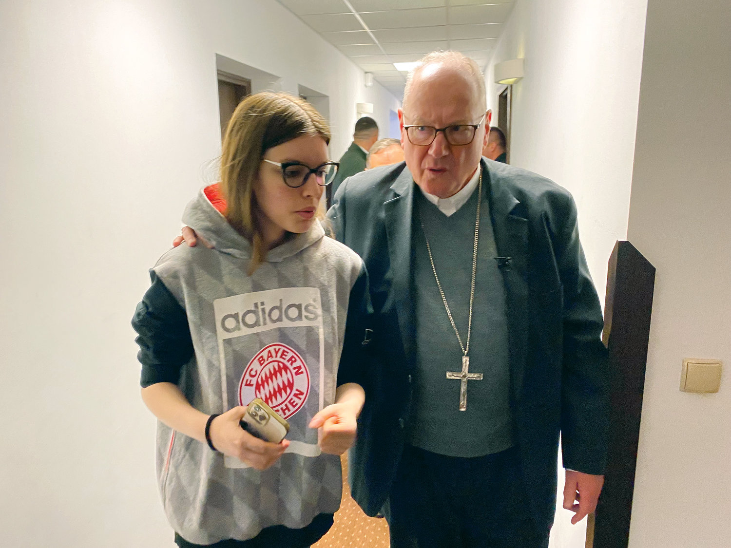 The cardinal walks May 2 with a young woman named Kate Shchawa, from Vorzel, near Kiev, at a refugee center for internally displaced persons in Lviv, Ukraine, where she is staying.