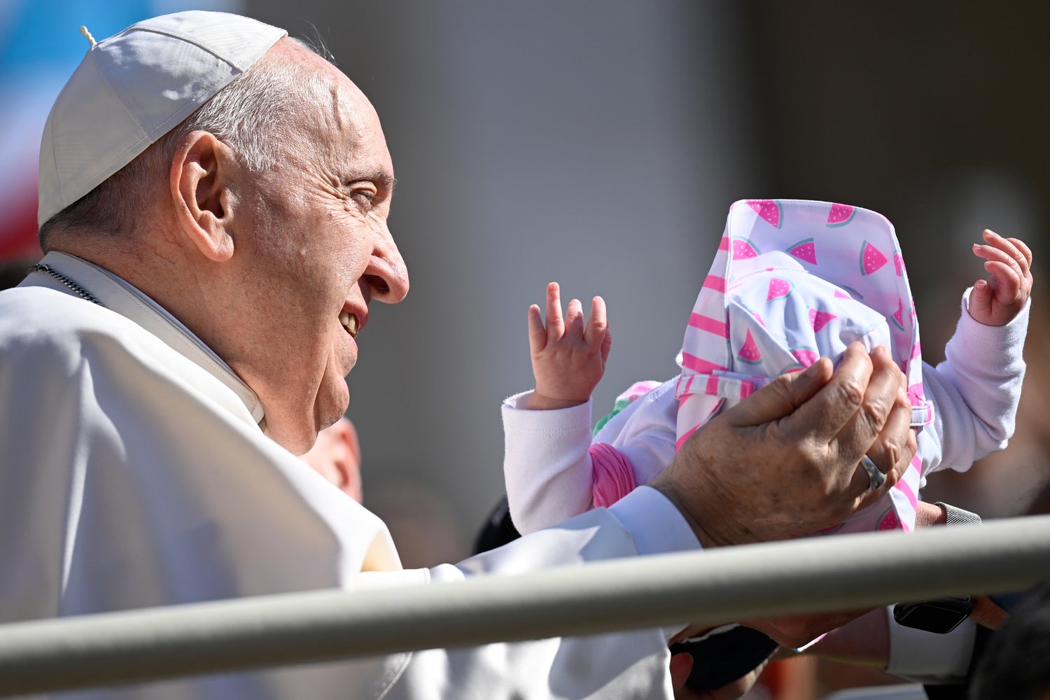 Pope Francis cradles a baby as he arrives for his general audience in St. Peter’s Square at the Vatican May 11.