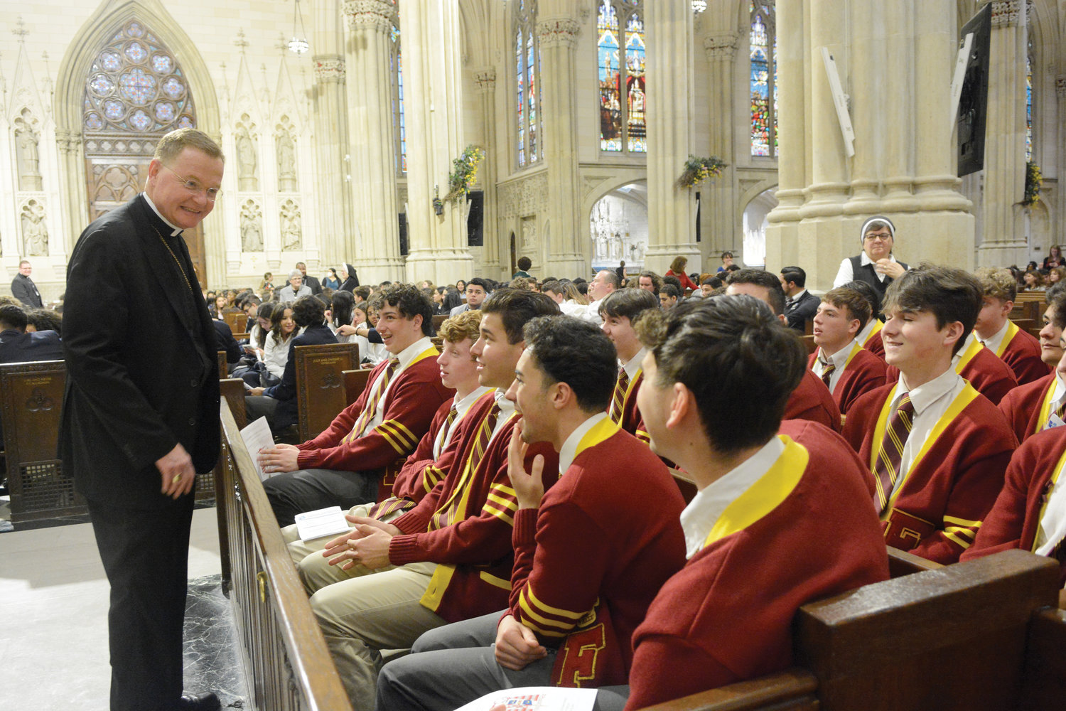 Auxiliary Bishop Edmund Whalen, a graduate and former principal of Msgr. Farrell High School on Staten Island, converses with members of Msgr. Farrell’s class of 2022.