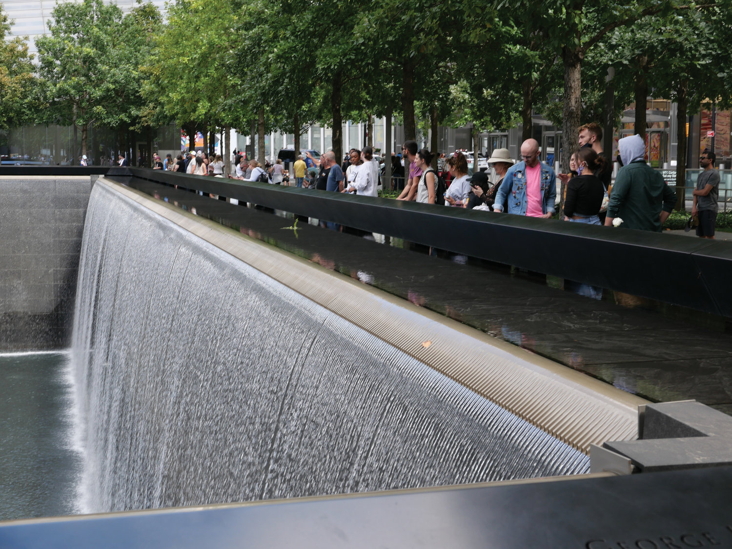 People gather around a reflecting pool of cascading water at the 9/11 Memorial in lower Manhattan Sept. 3, 2021.
