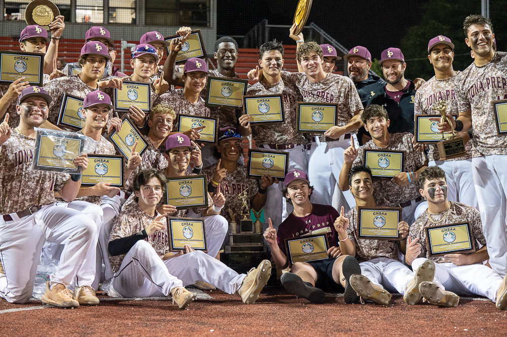 Iona Prep players and coaches hold their plaques for winning the CHSAA AA baseball city championship with a 3-2 victory over Msgr. Farrell High School at St. John’s University in Queens June 10.