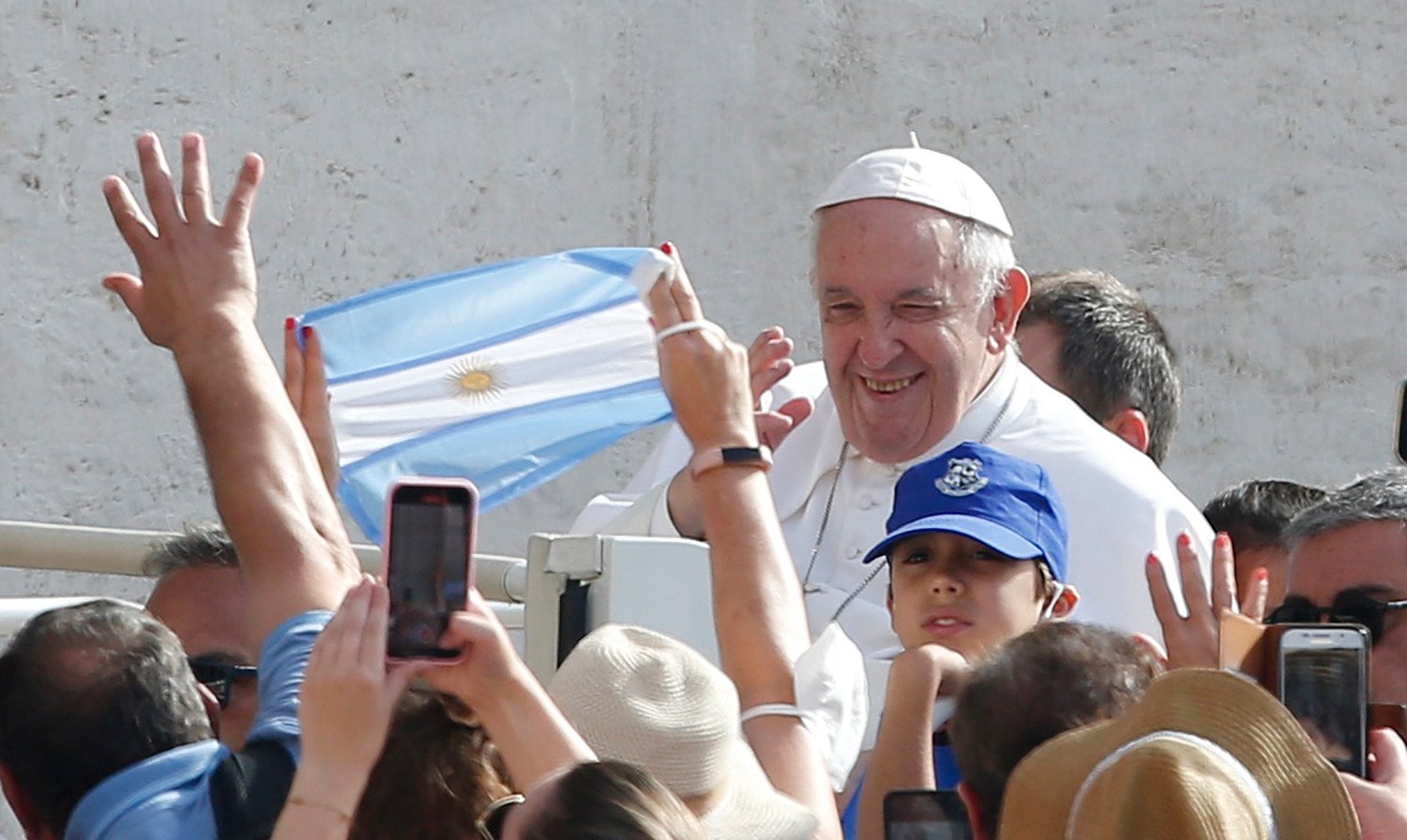 A pilgrim holds Argentina’s flag as Pope Francis greets the crowd during his general audience in St. Peter’s Square at the Vatican June 22.