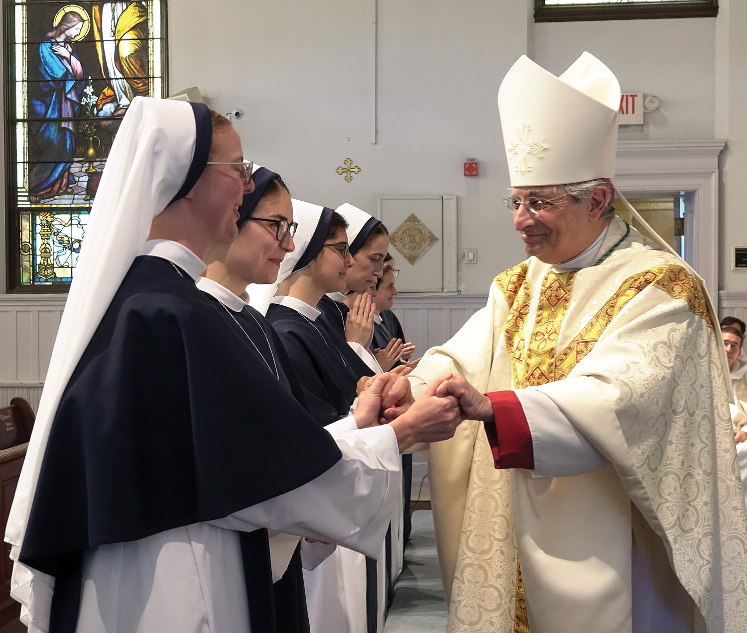 Bishop Salvatore Matano of the Diocese of Rochester hands out medals and greets the sisters.