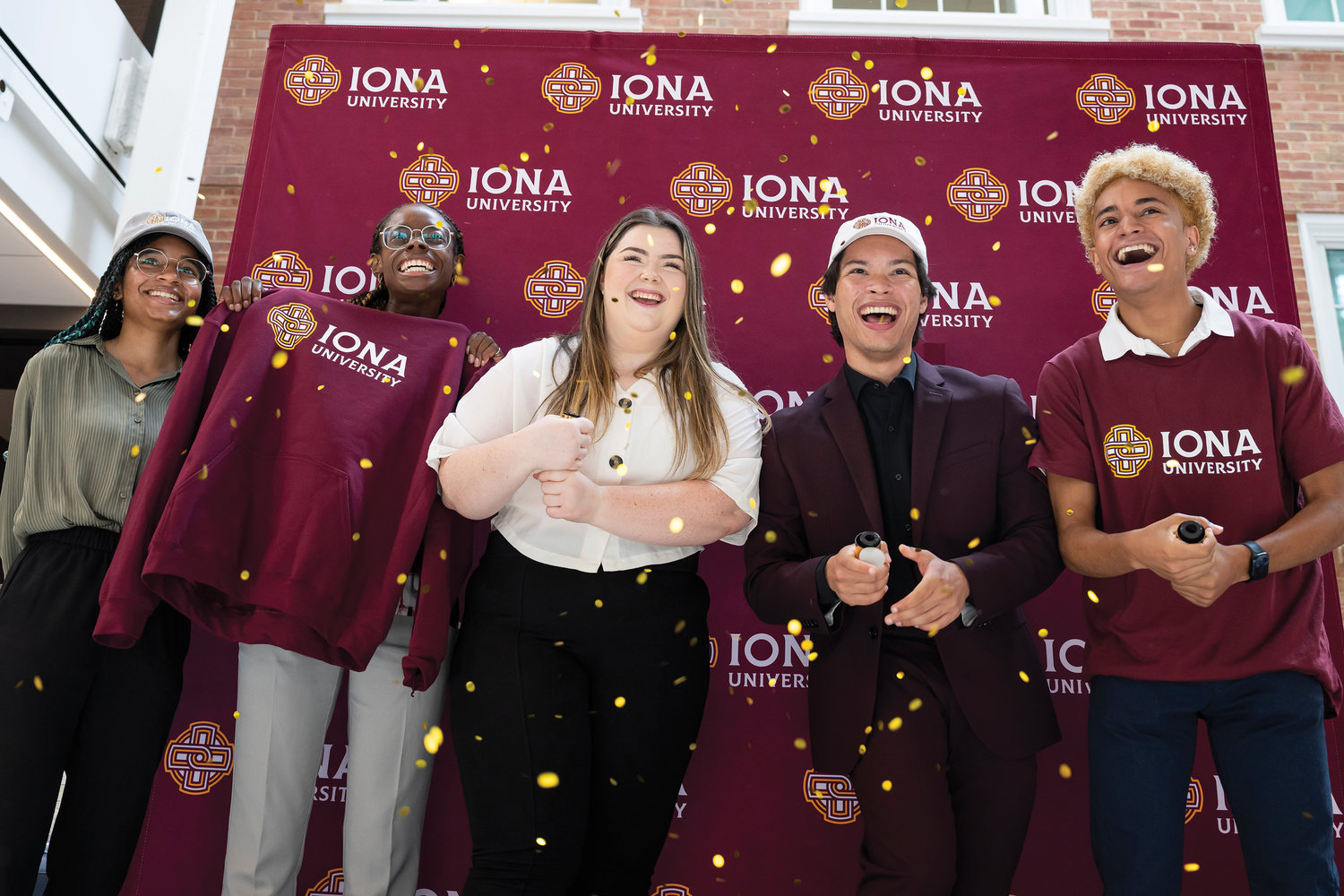 Iona University students in New Rochelle celebrate following the July 12 announcement that the institution’s name was changed from college to university. From left are Alesandra Payne ’24, Tonian Fullerton ’24, Maria Foley ’23, Brenden Martinez ’24 and Devon Gabriel ’23.
