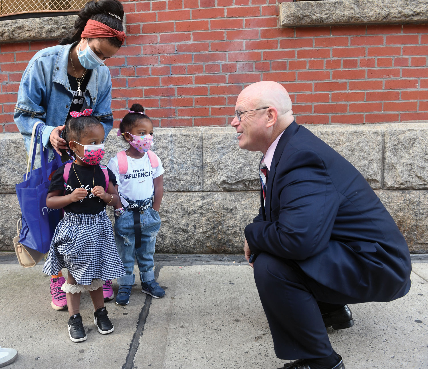 Michael Deegan, superintendent of schools for the archdiocese, greets Shiloh, left, and Amina Washington, white shirt, during the morning drop off at the Academy of St. Paul and St. Ann in East Harlem as the new academic year began last September. The youngsters were returning to start 3K.