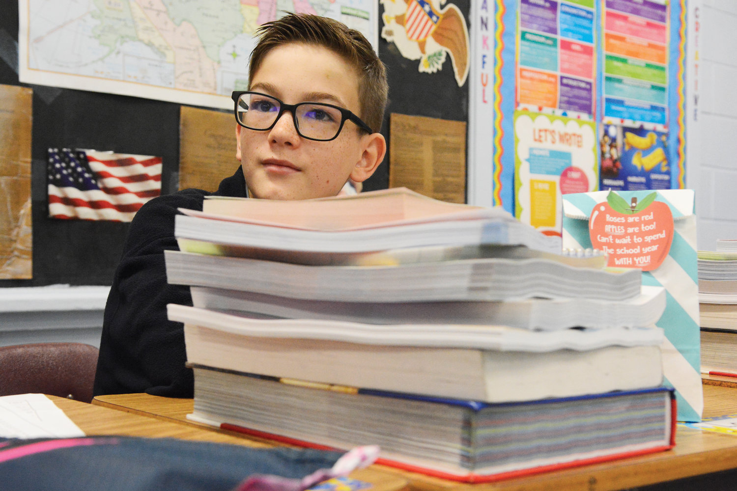 The books were piled high in front of seventh-grader Logan Claire.
