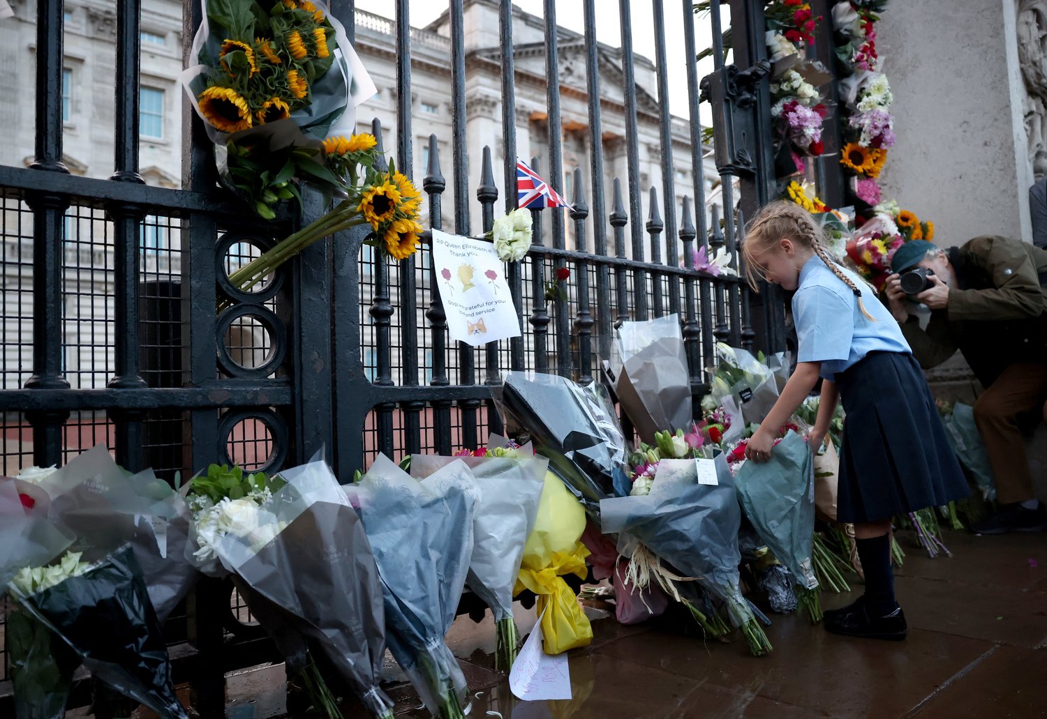 A girl places flowers outside Buckingham Palace in London Sept. 8 after Queen Elizabeth II— Britain’s longest-reigning monarch and the nation’s figurehead for seven decades—died at the age of 96.