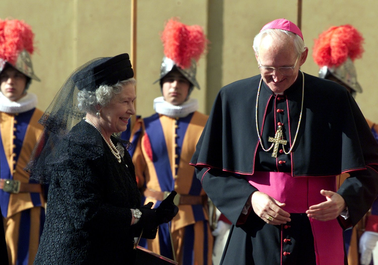 Britain’s Queen Elizabeth II is welcomed by U.S. Archbishop James Harvey, prefect of the papal household, as she arrives for her private audience with Pope John Paul II at the Vatican Oct. 17, 2000.