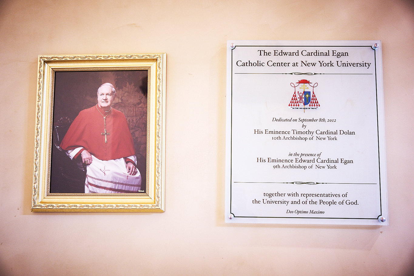 A portrait of Cardinal Egan is next to a plaque commemorating the center’s 2012 dedication by Cardinal Dolan in the presence of his predecessor.