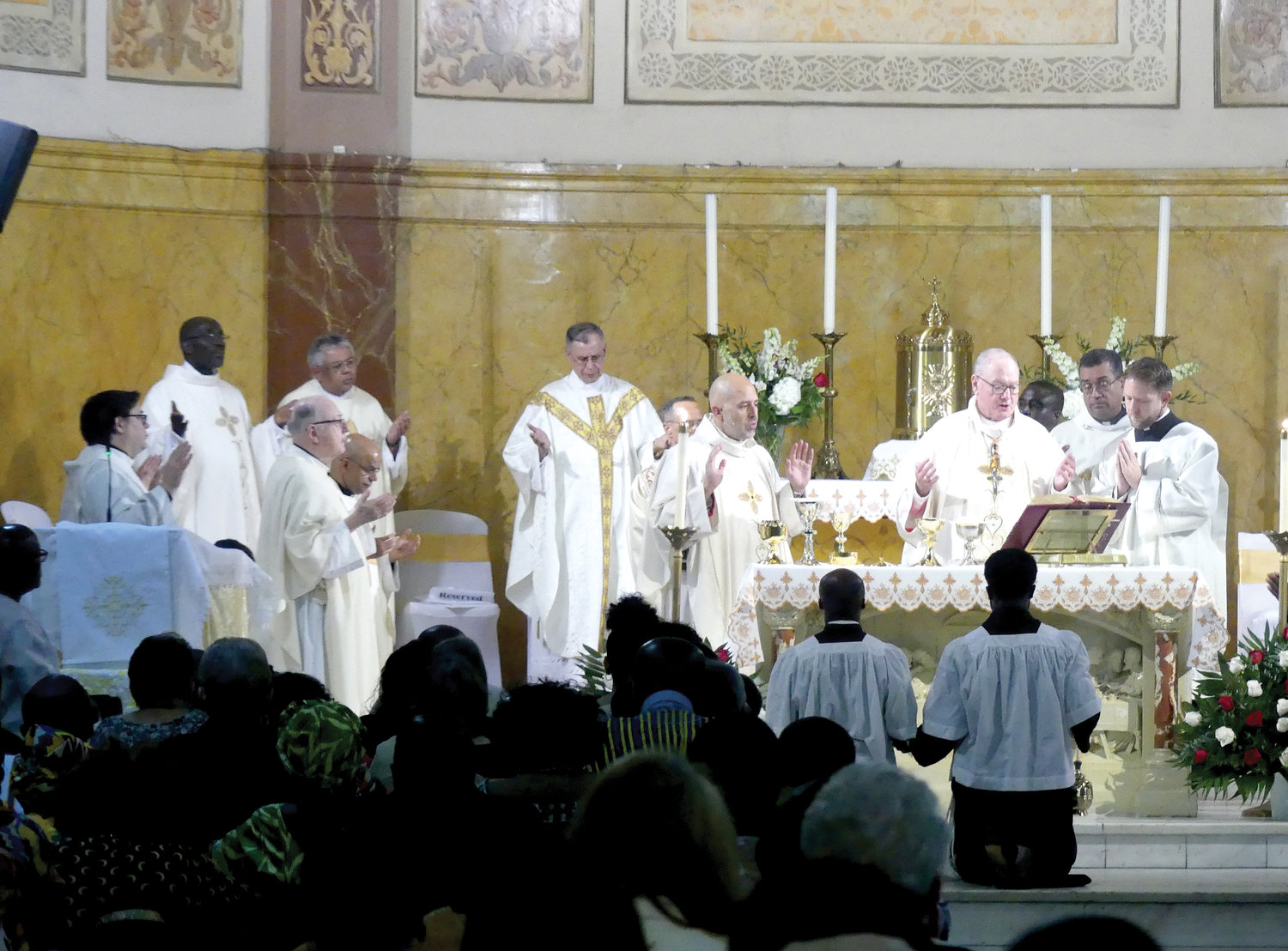 Cardinal Dolan consecrates the Eucharist at the Oct. 22 Mass commemorating the 125th anniversary of St. Luke’s parish in the Bronx. The cardinal, principal celebrant, noted the rich immigrant history of the parish community. To the left of the cardinal is Auxiliary Bishop Joseph Espaillat, and to his right is Father Eric Cruz, administrator of St. Luke’s.