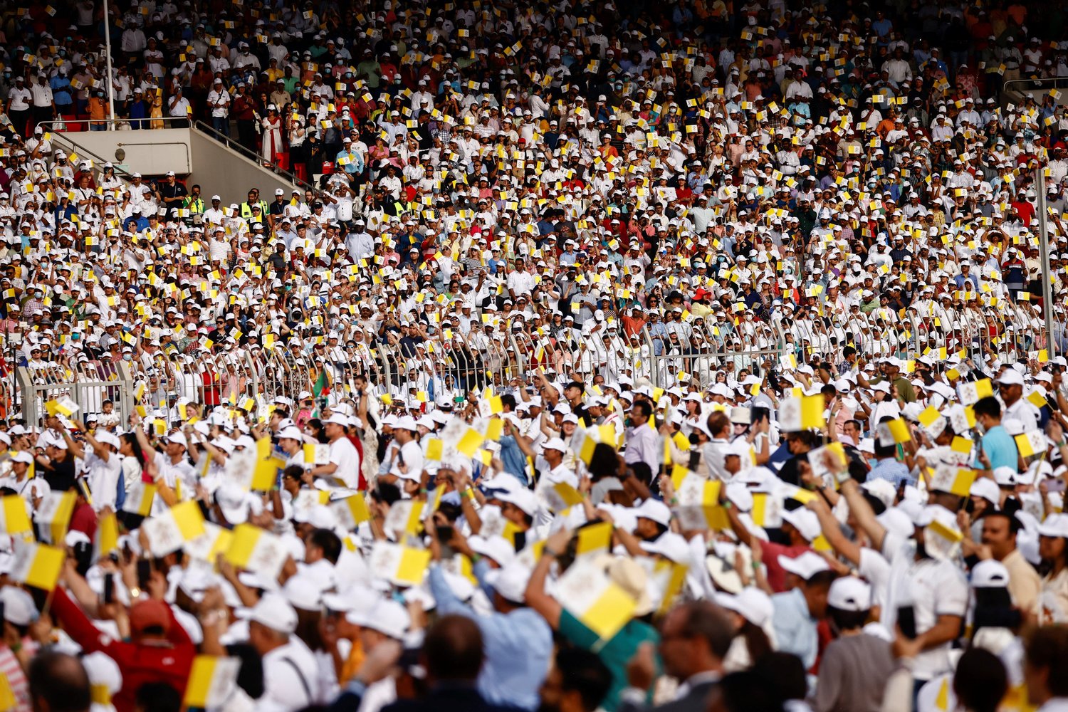 People wave Vatican flags as Pope Francis celebrates Mass at Bahrain National Stadium in Awali, Bahrain, Nov. 5.
